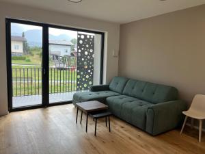 a living room with a green couch and a table at TB7 Sg in Slovenj Gradec