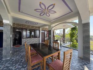 a dining room with a table and chairs at Adhikari mountain view homestay in Chaubattia