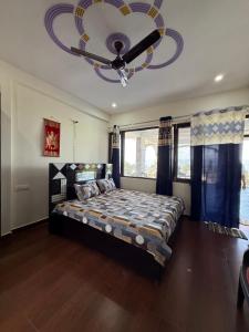 a bedroom with a large bed and a chandelier at Adhikari mountain view homestay in Chaubattia