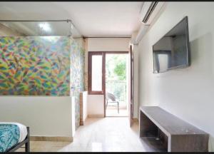 a room with a tv and a painting on the wall at Calangute house inn in Calangute