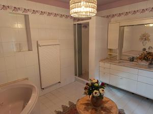 a bathroom with a tub and a vase of flowers on a table at L'Antica Dimora Toscana in Cecina