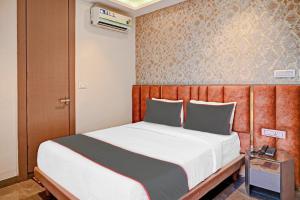 a bedroom with a large bed with a wooden headboard at Hotel O Vrindavan in Kolkata +28 photos