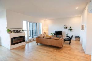 a living room with a couch and a fireplace at 309 - Luxury Condo - Spectacular View & Pool in Baie-Saint-Paul +60 photos
