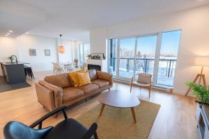 a living room with a couch and a table at 309 - Luxury Condo - Spectacular View & Pool in Baie-Saint-Paul