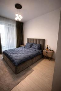 a bedroom with a large bed and a table at Herastrau Prestige Apartment WIN in Bucharest