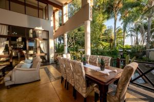 an outdoor dining room with a wooden table and chairs at Stille Woning Guesthouse in White River