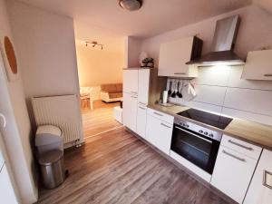 a kitchen with white cabinets and a stove top oven at Haus Seeglück in Röbel