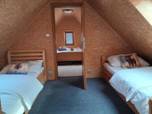a attic bedroom with two beds and a mirror at Chata na farmě Petrovice in Mladošovice