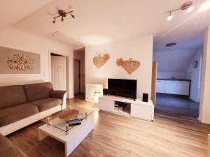 a living room with a couch and a flat screen tv at Haus Seeglück in Röbel