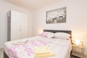 a bedroom with a large bed with pink and white sheets at Apartments Baltazar with Sea View&Jacuzzi in Dubrovnik