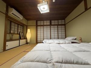 a room with four large white beds in it at Senbonzakura Yoshino in Yoshino
