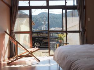 a bedroom with a bed and a window with a car outside at Senbonzakura Yoshino in Yoshino