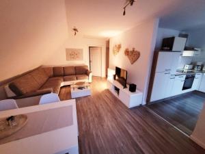 a large living room with a couch and a kitchen at Haus Seeglück in Röbel +9 photos