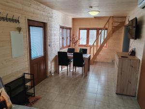 a dining room with a table and chairs and a staircase at Chata na farmě Petrovice in Mladošovice