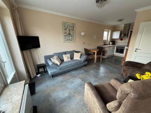 a living room with a couch and a kitchen at Leuchtturm 1 in Fehmarn +7 photos