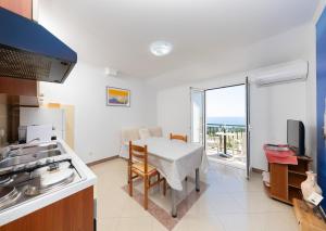 a kitchen with a table and a dining room at Apartments Baltazar with Sea View&Jacuzzi in Dubrovnik