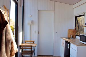 a kitchen with a door and a table and chairs at Hill River Nature Reserve by Tiny Away in Jurien Bay