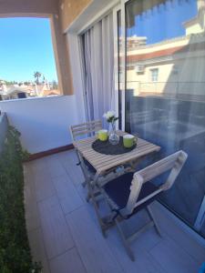 a wooden table and chairs on a balcony with a window at Studio with Pool BENALMADENA in Benalmádena +4 photos