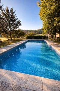 a swimming pool with blue water in a yard at Maisonnette avec piscine - sud Ardèche in Saint-Montan