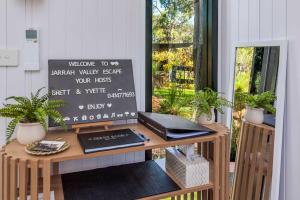 a desk with a laptop on it next to a window at Jarrah Valley Escape by Tiny Away in Bedfordale