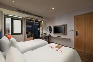 a hotel room with two beds and a television at Solar Premium Hotel & Spa in Hanoi