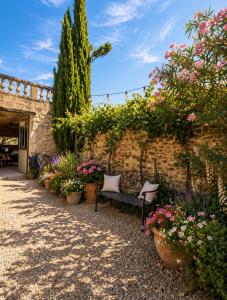 a bench in a garden with flowers and plants at Maisonnette avec piscine - sud Ardèche in Saint-Montan