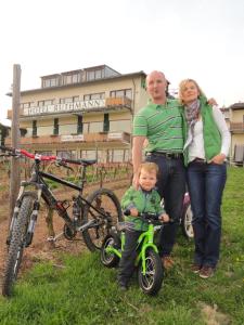 a man and a woman standing next to a child on a bike at RUTHMANN-Rheinblick GARNI in Oestrich-Winkel