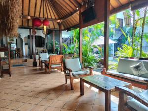 a patio with chairs and tables and a table at Mojo Resort Canggu in Canggu