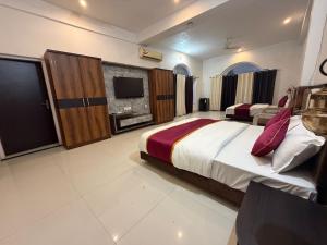 a large bedroom with a large bed and a tv at Silver Lake View Resort in Barhi