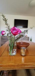 a vase with a pink flower on a wooden table at Rheinufer in Xanten