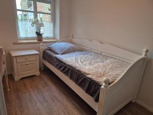 a white bed in a bedroom with a window at Entspannen auf der Old Charmi Ranch in Kutenholz