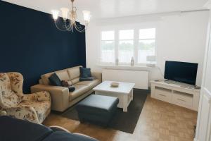 a living room with a couch and a tv at Entspannen auf der Old Charmi Ranch in Kutenholz