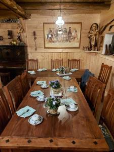 a large wooden table in a wooden room with chairs at Entspannen auf der Old Charmi Ranch in Kutenholz