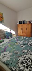 a bedroom with a bed with a floral comforter at Rheinufer in Xanten