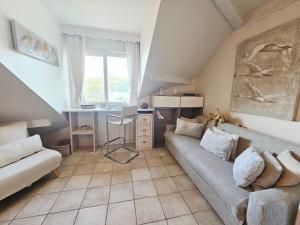 a living room with a couch and a desk at L'Escale au Lac - Vue panoramique - parking & plage privés in Duingt