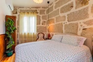 a bedroom with a bed and a stone wall at Casa da Avó Selene - Refúgio Rústico e Exclusivo no Douro in Favaios