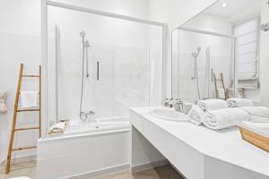 a white bathroom with a white tub and a sink at Villa Claudia Hotel Cannes Centre - Parking in Cannes