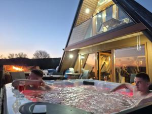 two men in a hot tub with a glass of wine at Mountain house Tomislavgrad with Jacuzzi in Tomislavgrad +54 photos