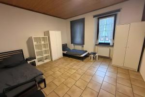 a bedroom with a bed and a couch and a window at Viel Platz und Komfort in Orbis