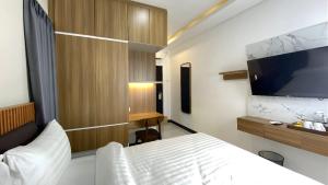 a bedroom with a bed and a flat screen tv at Koa Living Semarang in Kalibanteng-kidul