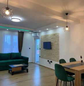 a living room with a green couch and a table at Vila Ideal in Donji Štoj