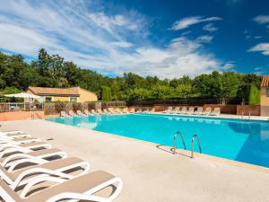 a large swimming pool with lounge chairs in a resort at Mazets Zomeno in Gaujac