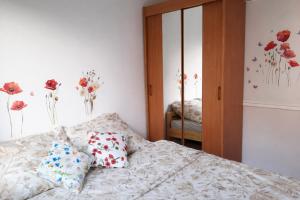 a bedroom with a bed with flowers on the wall at Apartament Bałtycka Sardynka in Ustka