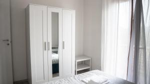 a white cabinet with a mirror in a bedroom at Residenza Madea - Vista Mare, Piscina, Spiaggia Privata e Parcheggio in Marina di Andora +30 photos