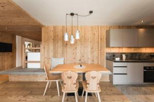 a kitchen with a wooden table and chairs at Wieserhof Family Farm in Maranza