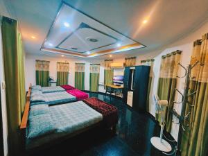 two beds in a room with green curtains at GB 25 cottage's in Trivandrum