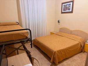 a hospital room with two beds and a window at Hotel Reno in Lido di Savio