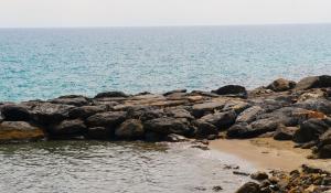 a group of rocks on a beach near the water at Residenza Madea - Vista Mare, Piscina, Spiaggia Privata e Parcheggio in Marina di Andora
