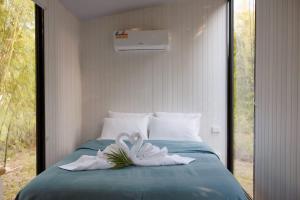 two swans sitting on top of a bed at Bamboo Grove by Tiny Away in Bauple