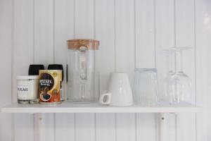 a white shelf with various kitchen items on it at Bamboo Grove by Tiny Away in Bauple +37 photos